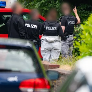 Polizeibeamte und Ermittler der Spurensicherung untersuchen den Tatort im Kieler Stadtteil Gaarden-Süd.