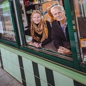 Die ehrenamtlichen Zuhörer Katharina McLean (l.) und Christoph Busch stehen am Fenster des Kiosk.