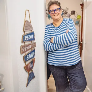 Die „Wegovy“-Patientin Beate Rauch lehnt an einem Türrahmen und lächelt in die Kamera.