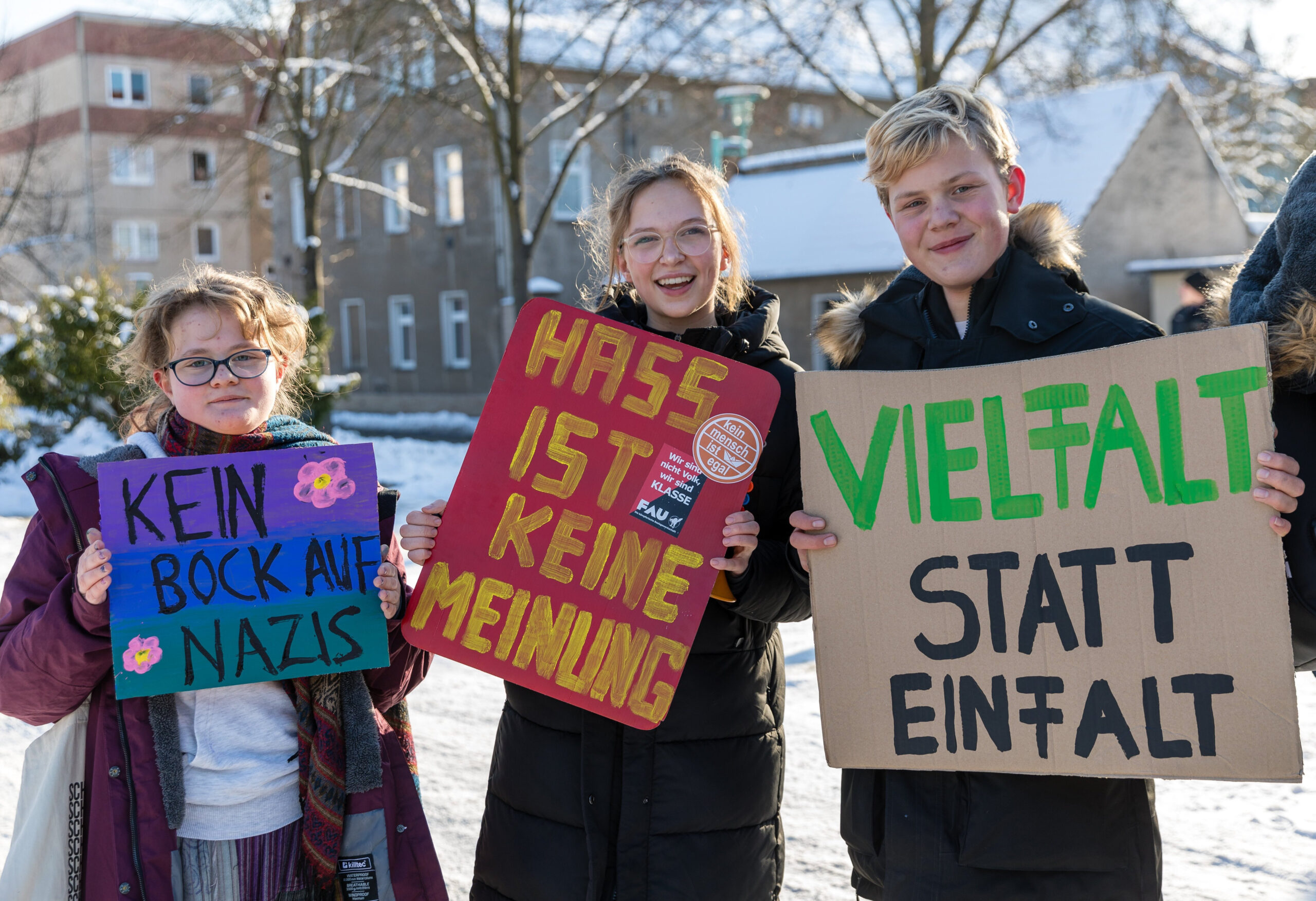 Drei Kinder in Spremberg halten Plakate mit Sprüchen gegen rechts hoch.