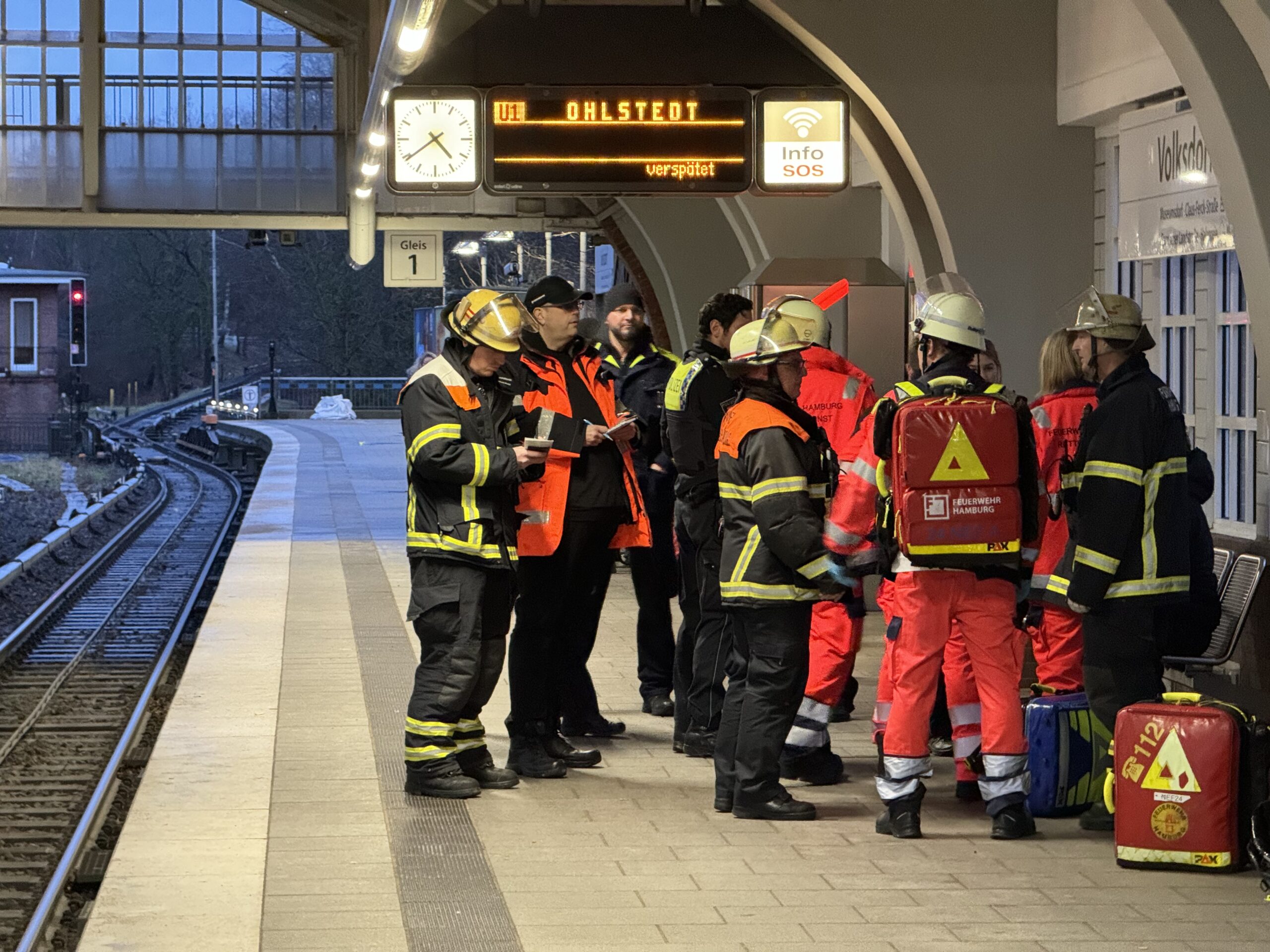 Einsatzkräfte der Polizei und der Feuerwehr stehen nach der Rettung des Mannes auf dem Bahnsteig der U-Bahnstation Volksdorf.
