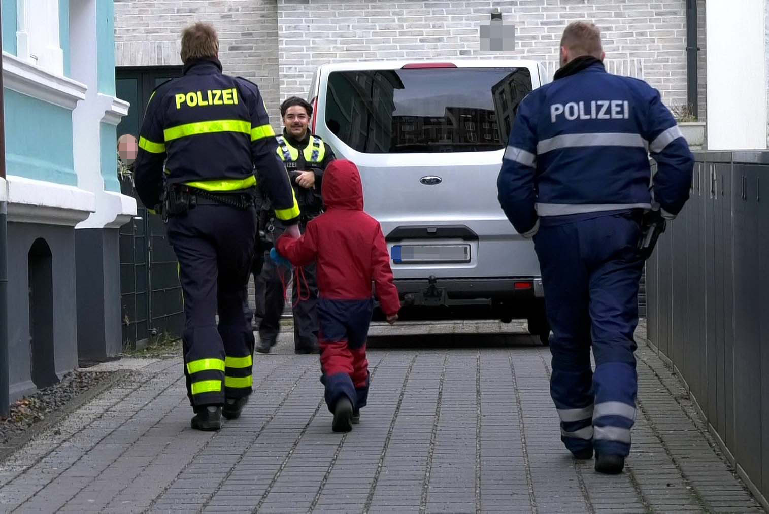 Ein Polizist bringt den Kleinen wohlbehalten zu den Eltern zurück.