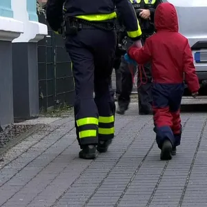 Ein Polizist bringt den Kleinen wohlbehalten zu den Eltern zurück.