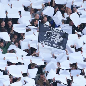 Eine weiße Choreografie, in der Mitte ein Banner mit Aufschrift „St. Pauli gegen Rechts“