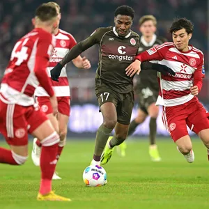 Oladapo Afolayan im Zweikampf mit mehreren Düsseldorfern