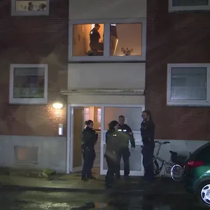 Polizisten vor dem Wohnhaus in Glückstadt.