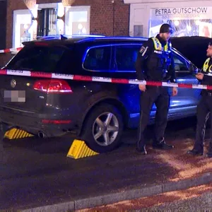 Polizisten haben den Einsatzort rund um den SUV abgesperrt.