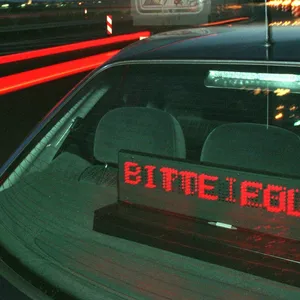 Ein Polizeiwagen, an der Heckscheibe leuchtet der Schriftzug "Bitte folgen" auf