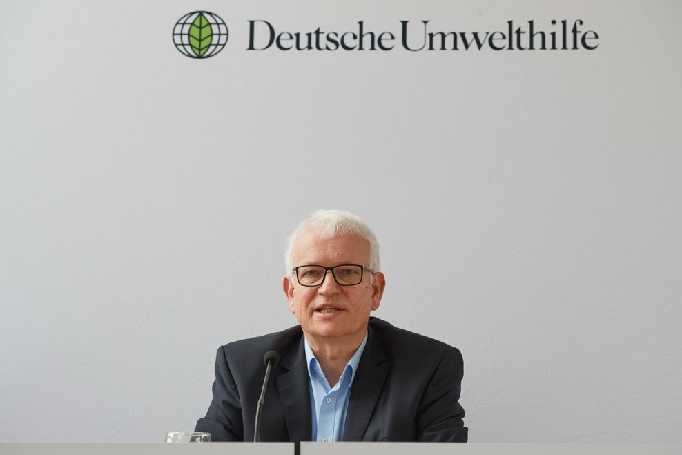 Weißhaariger Mann vor Schild: „Deutsche Umwelthilfe“