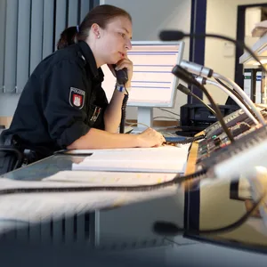 Eine Polizistin telefoniert in der Leitstelle (Symbolbild).