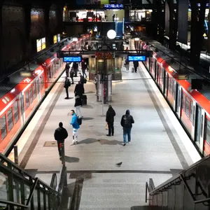 Menschen steigen am Hauptbahnhof in zwei S-Bahnen ein und aus.