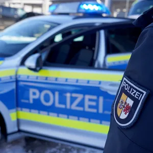 Eine Beamtin der Polizei Mecklenburg-Vorpommern steht neben einem Einsatzfahrzeug.