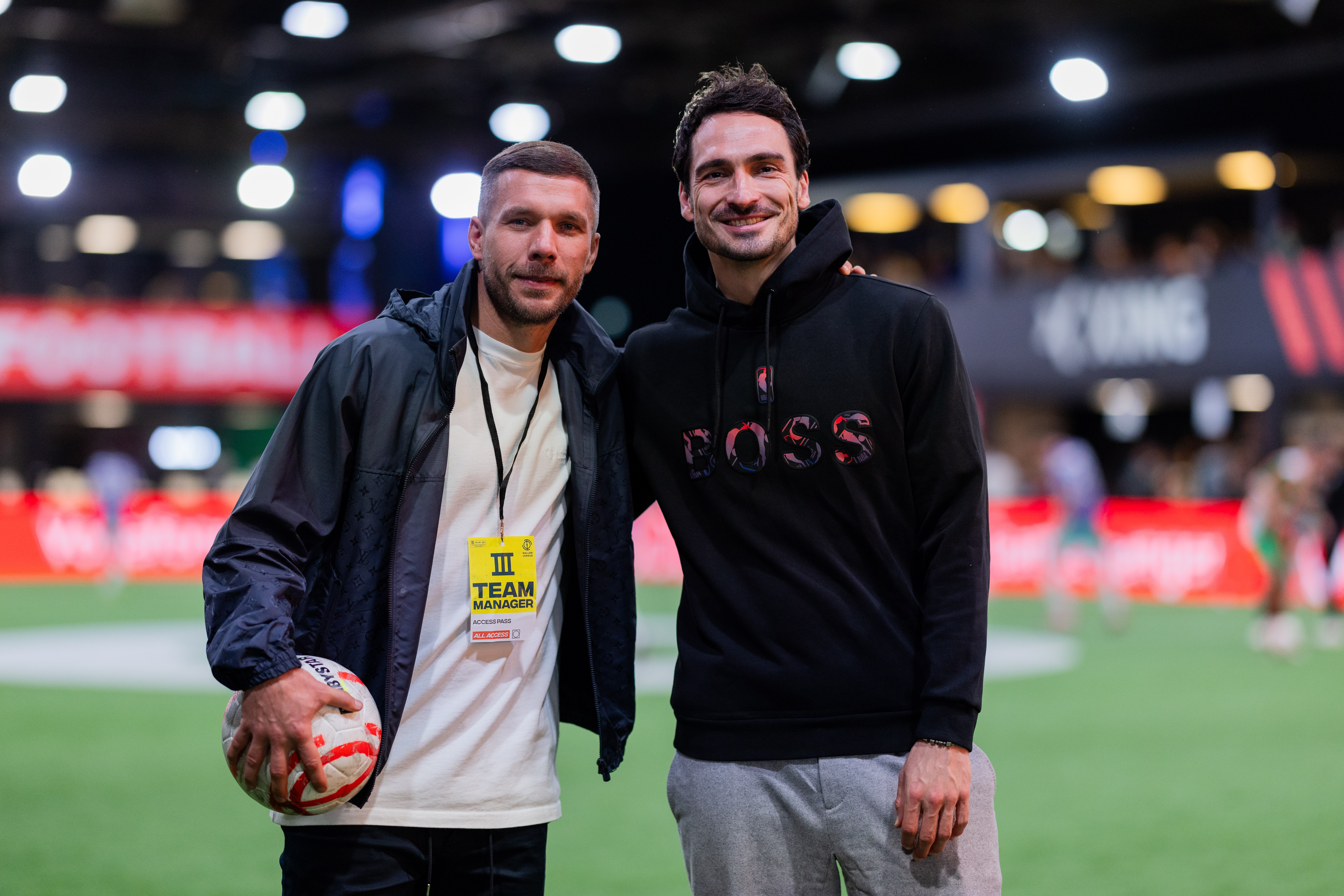 Lukas Podolski und Mats Hummels posieren lächelnd am Spieltag der Baller League