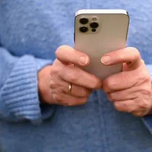 Eine Frau tippt auf ihrem Handy.