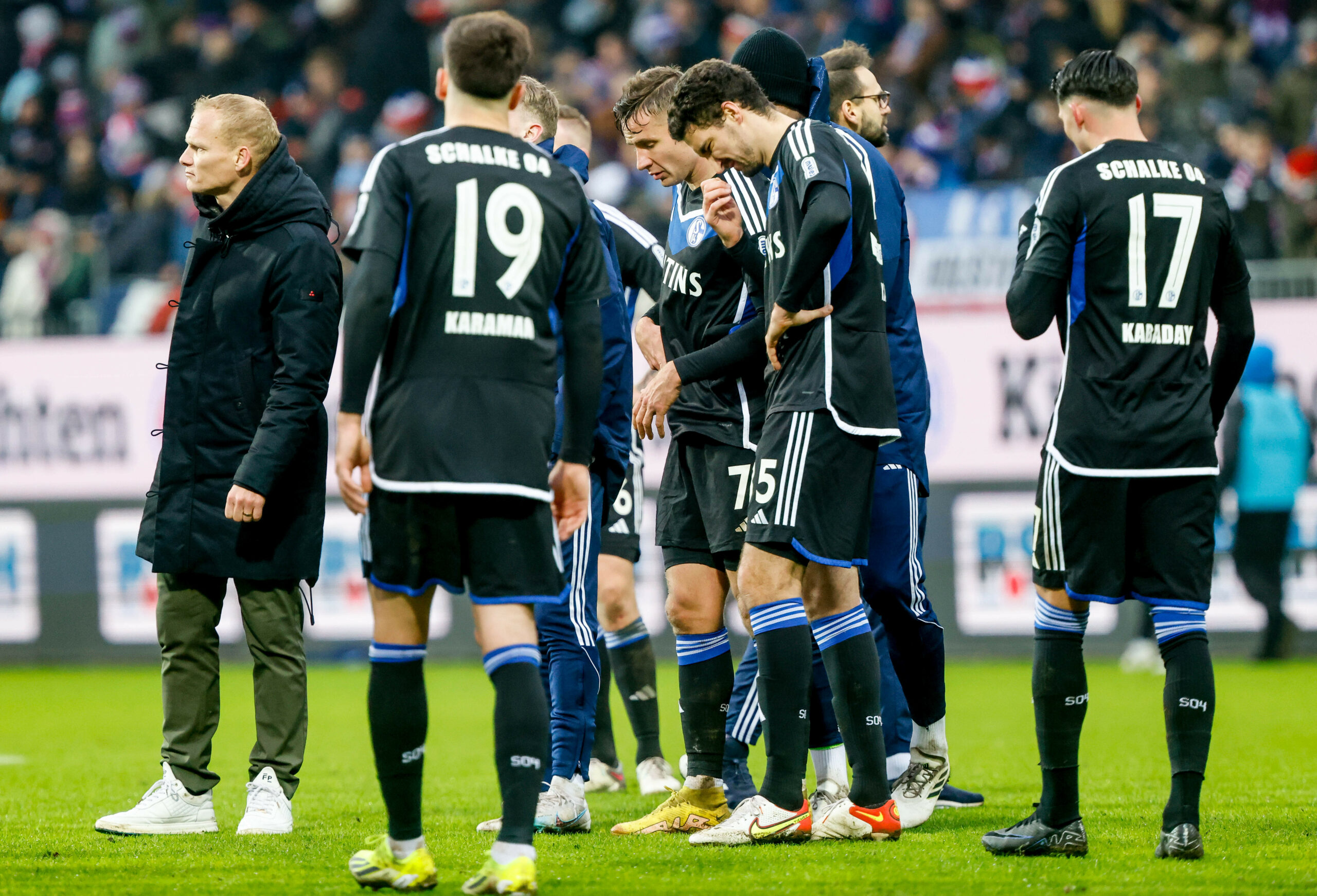 Spieler von Schalke 04 stehen nach einer Niederlage enttäuscht auf dem Spielfeld.