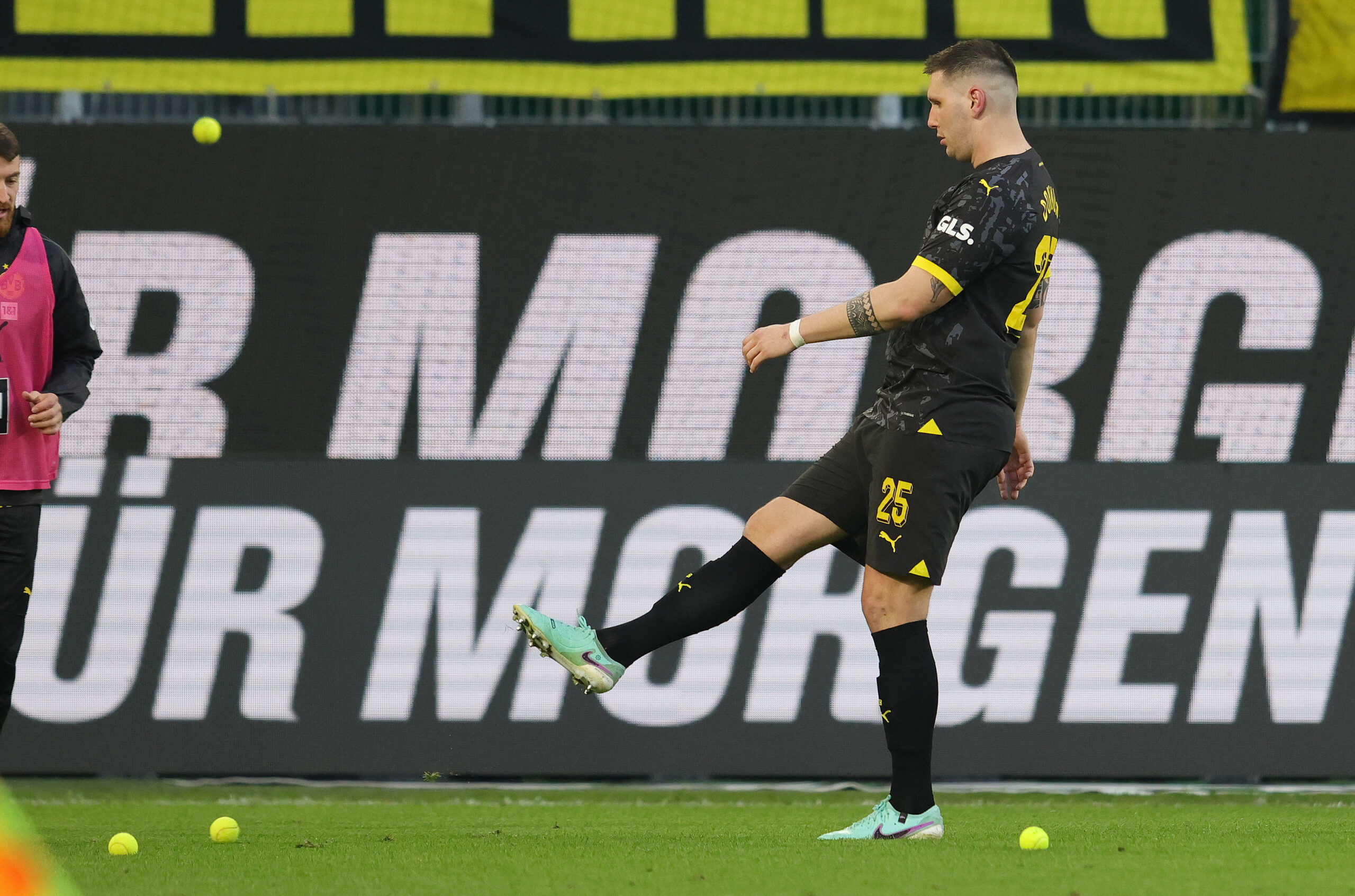 Dortmunds Niklas Süle kickt auf das Spielfeld geworfene Tennisbälle vom Rasen.