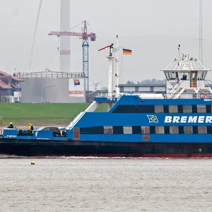 Eine Weserfähre ist bei trübem Wetter auf der Weser unterwegs.