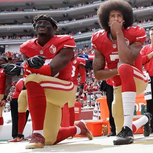 Eli Harold, Colin Kaepernick, Eric Reid knien zum Protest gegen Rassismus.