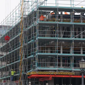 Bauarbeiter stehen auf einem Baugerüst an einer Baustelle in der Innenstadt.