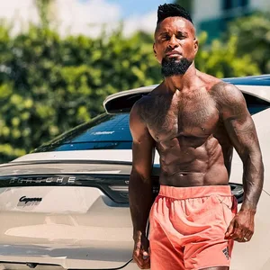 Ze Roberto posiert oberkörperfrei vor seinem Porsche.