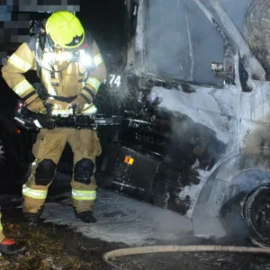 Feuerwehrkräfte löschen den brennenden Sprinter.