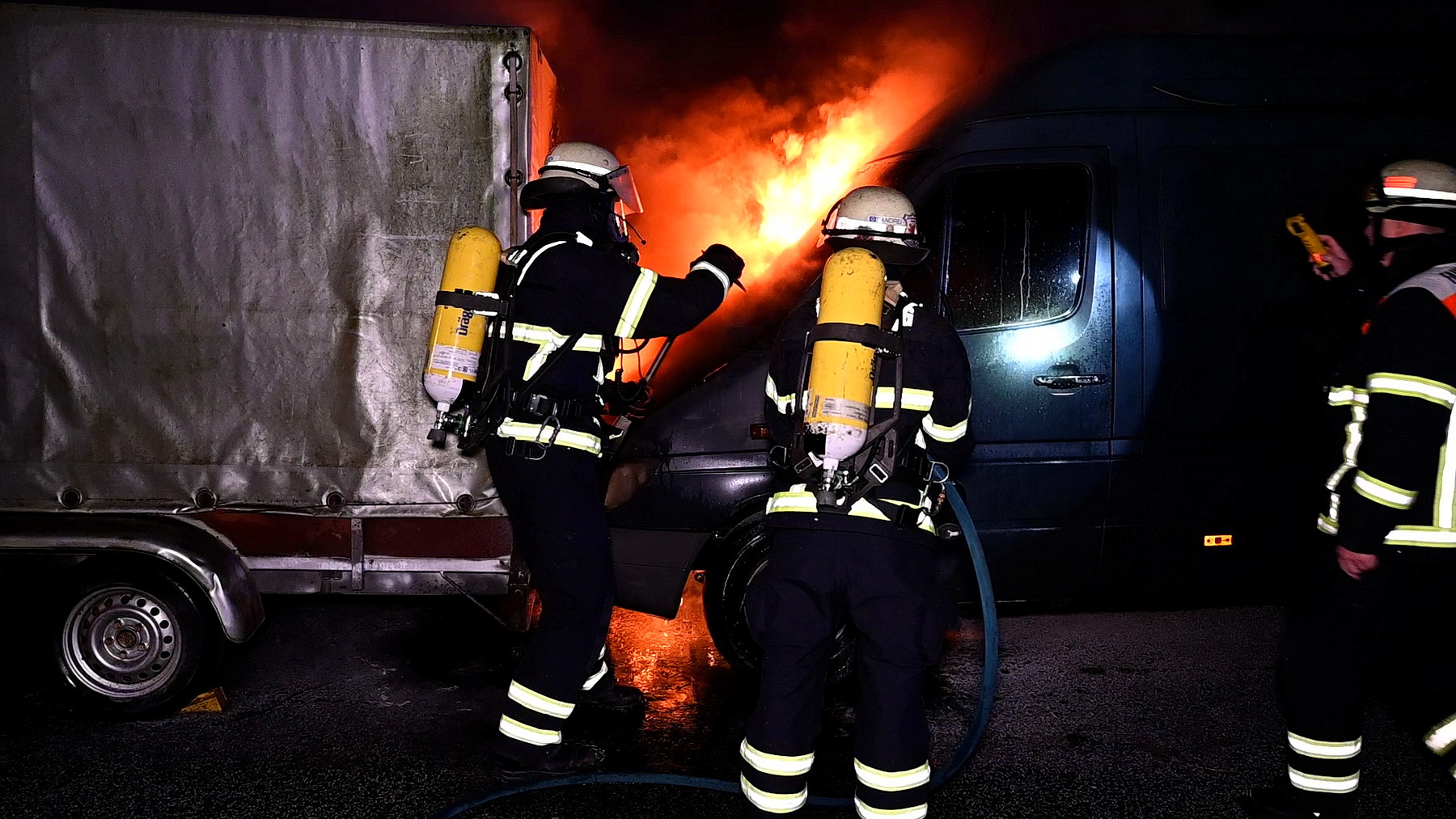 Feuerwehrkräfte löschen die Flammen am Transporter.