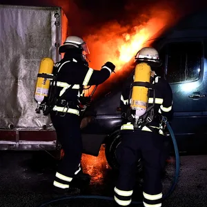 Feuerwehrkräfte löschen die Flammen am Transporter.
