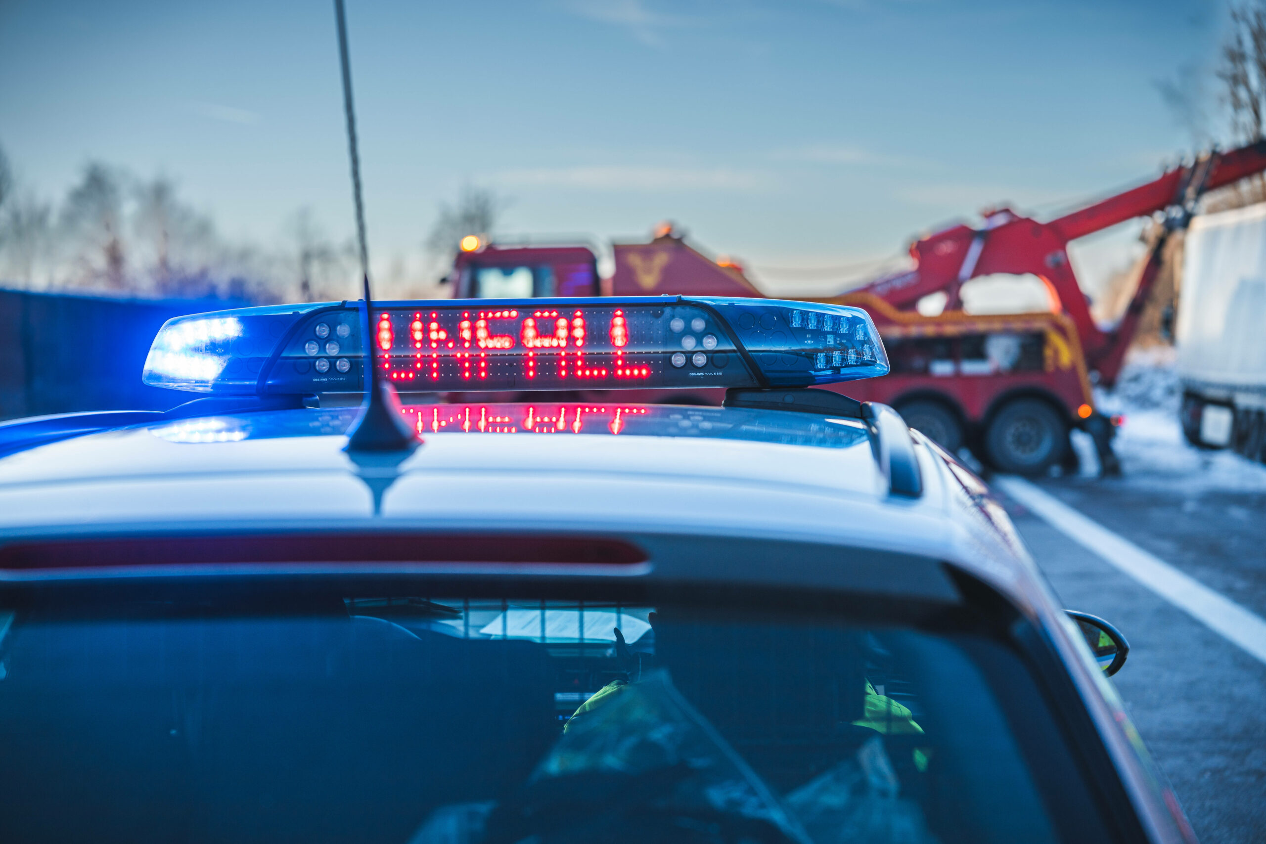 Ein Polizeiwagen mit Blaulicht und der leuchtenden Aufschrift „Unfall“
