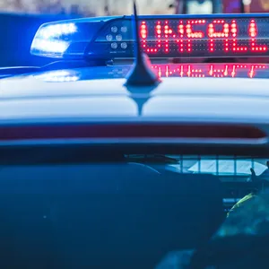 Ein Polizeiwagen mit Blaulicht und der leuchtenden Aufschrift „Unfall“