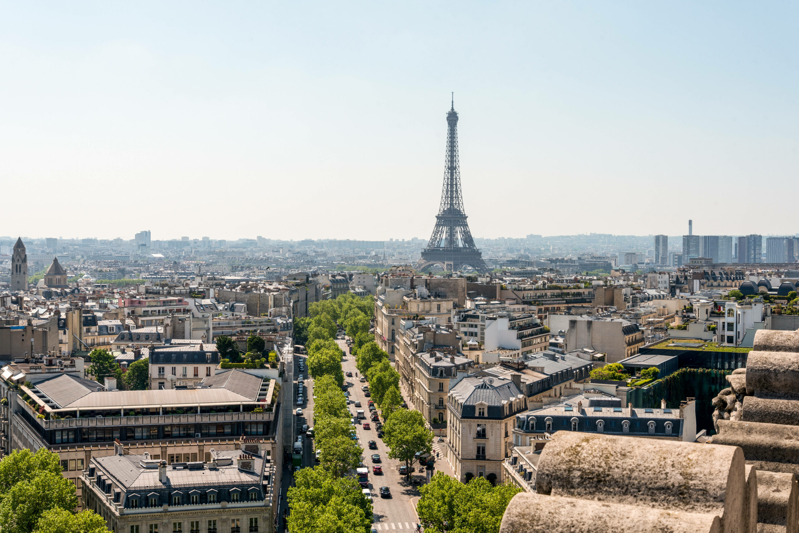 Der Eiffelturm in der Ferne ragt zwischen den Häusern von Paris hervor.