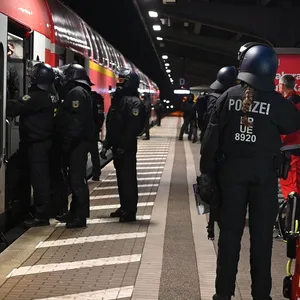 Polizisten halten einen Zug mit HSV-Anhängern am Bergedorfer Bahnhof an.