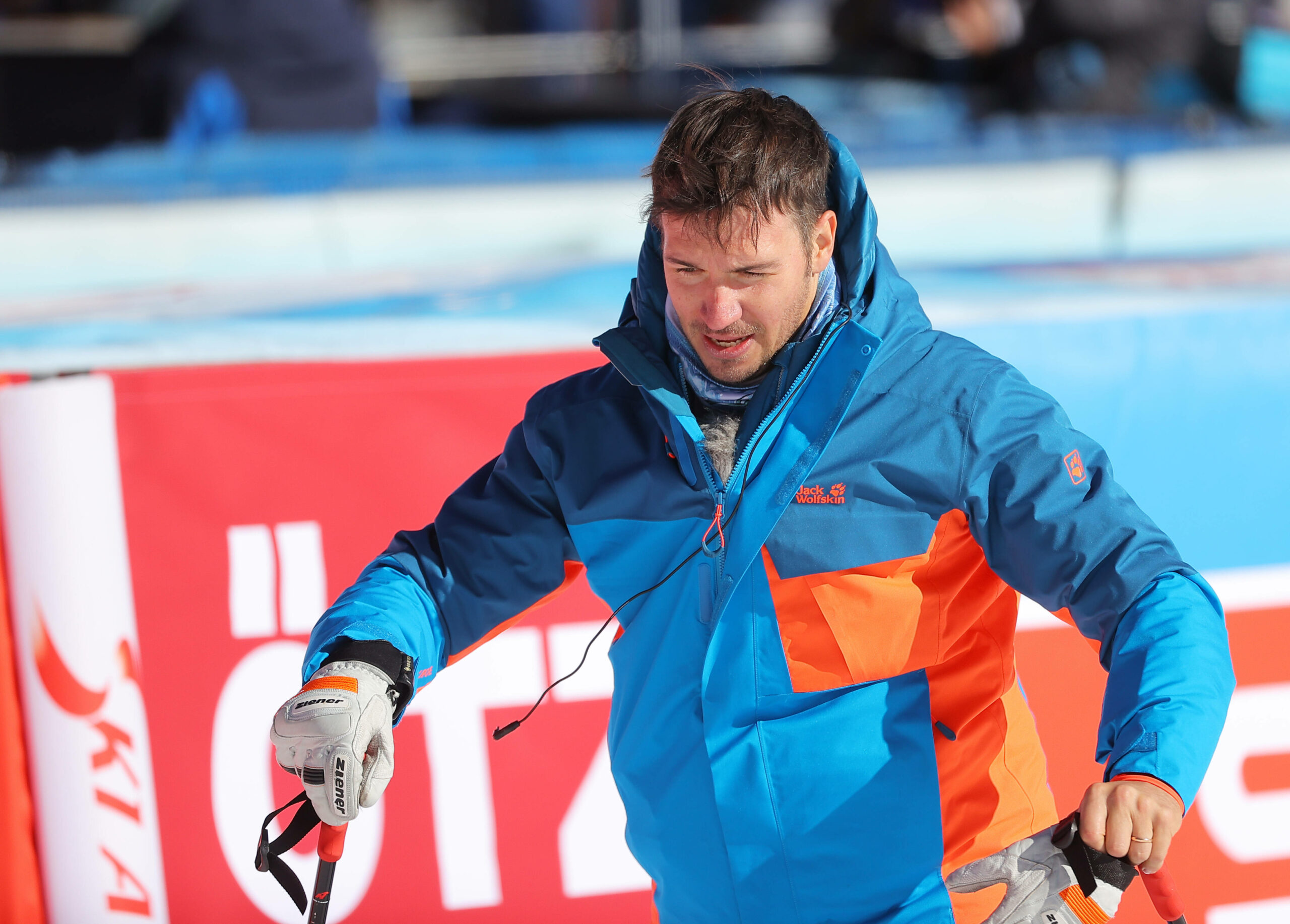 Felix Neureuther in Winterjacke und mit Ski-Stöcken in den Händen.