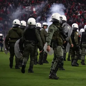 Polizisten in voller Montur auf dem Rasen im Stadion.