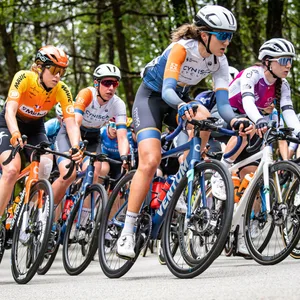 Eine Rennradfahrerin des Teams Cynisca Cycling bei einem Wettkampf mit anderen Teilnehmenden.