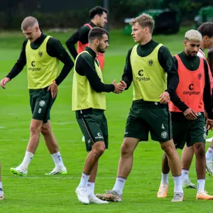 Die St. Pauli-Spieler David Nemeth und Danel Sinani klatschen sich im Training ab