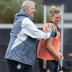 Horst Hrubesch (l.) schubst Alexandra Popp - Beide lächeln.