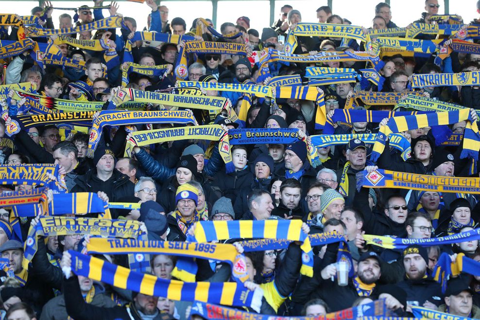 Fans von Eintracht Braunschweig halten Fan-Schals in die Höhe