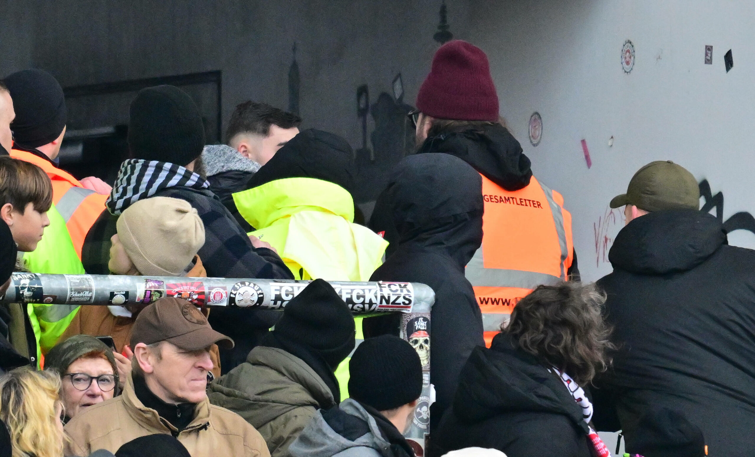 Der mutmaßliche Böllerwerfer )(verdeckt) wird von Ordnern aus dem Stadion geleitet.