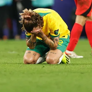Jackson Irvine hat die Hände vor seinem Gesicht und kniet am Boden auf dem Spielfeld.
