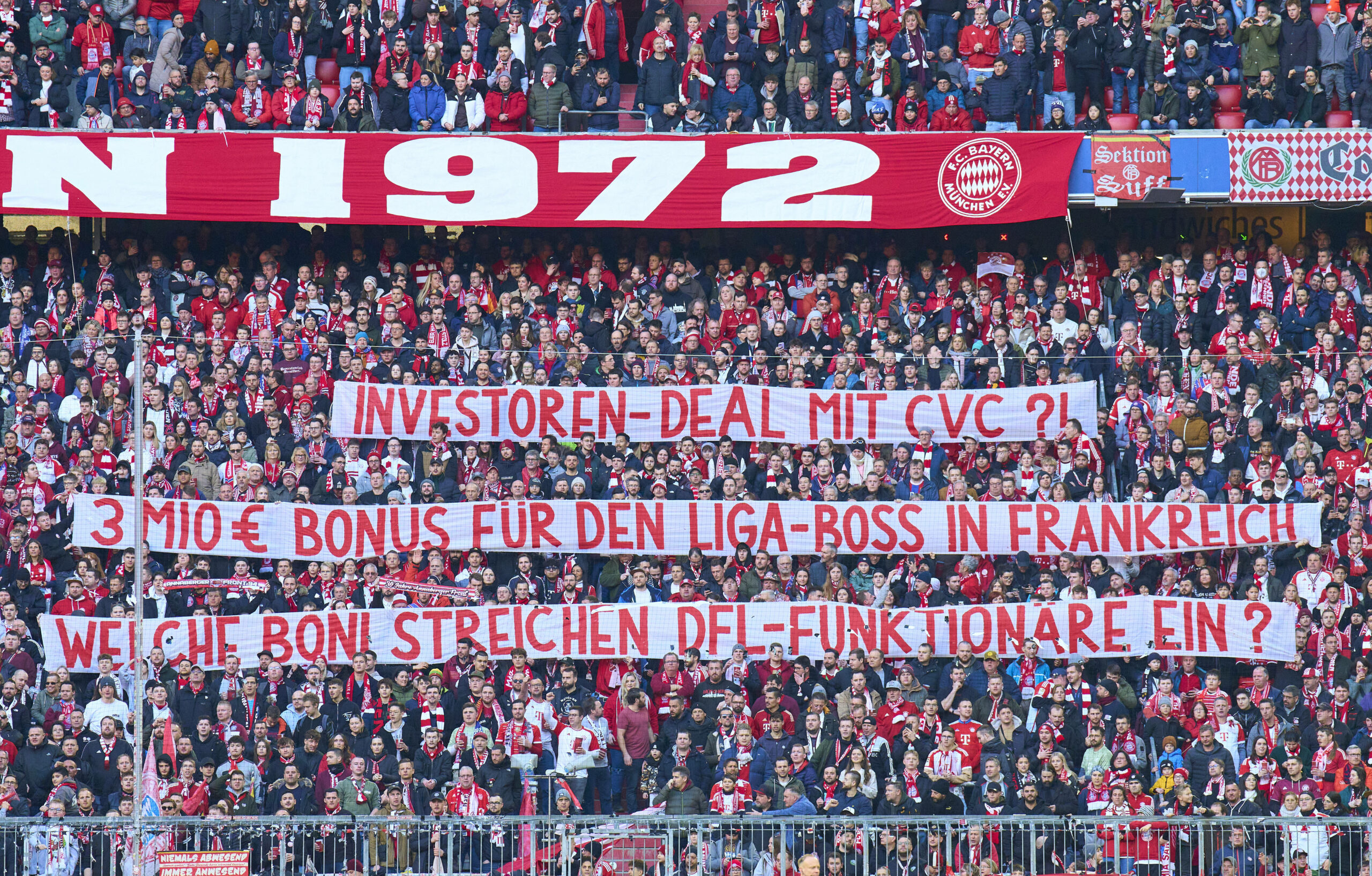 Fans des FC Bayern mit Plakaten gegen den Einstieg von CVC.