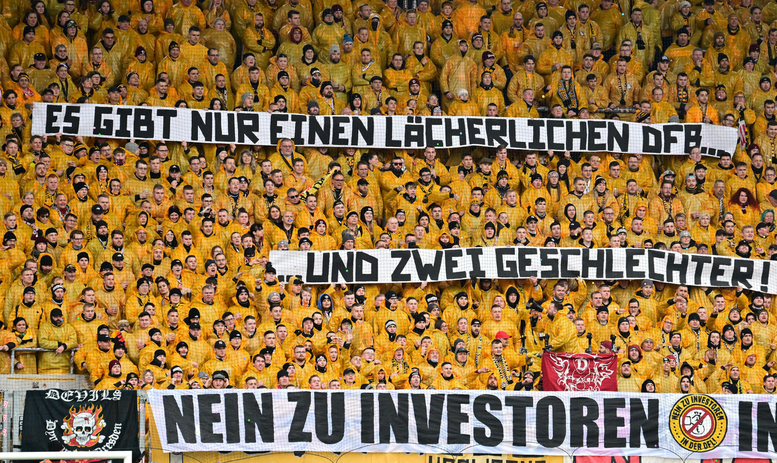 Dynamo Dresden-Fans halten ein Banner hoch, auf dem geschrieben steht: „Es gibt nur einen lächerlichen DFB, und nur zwei Geschlechter“