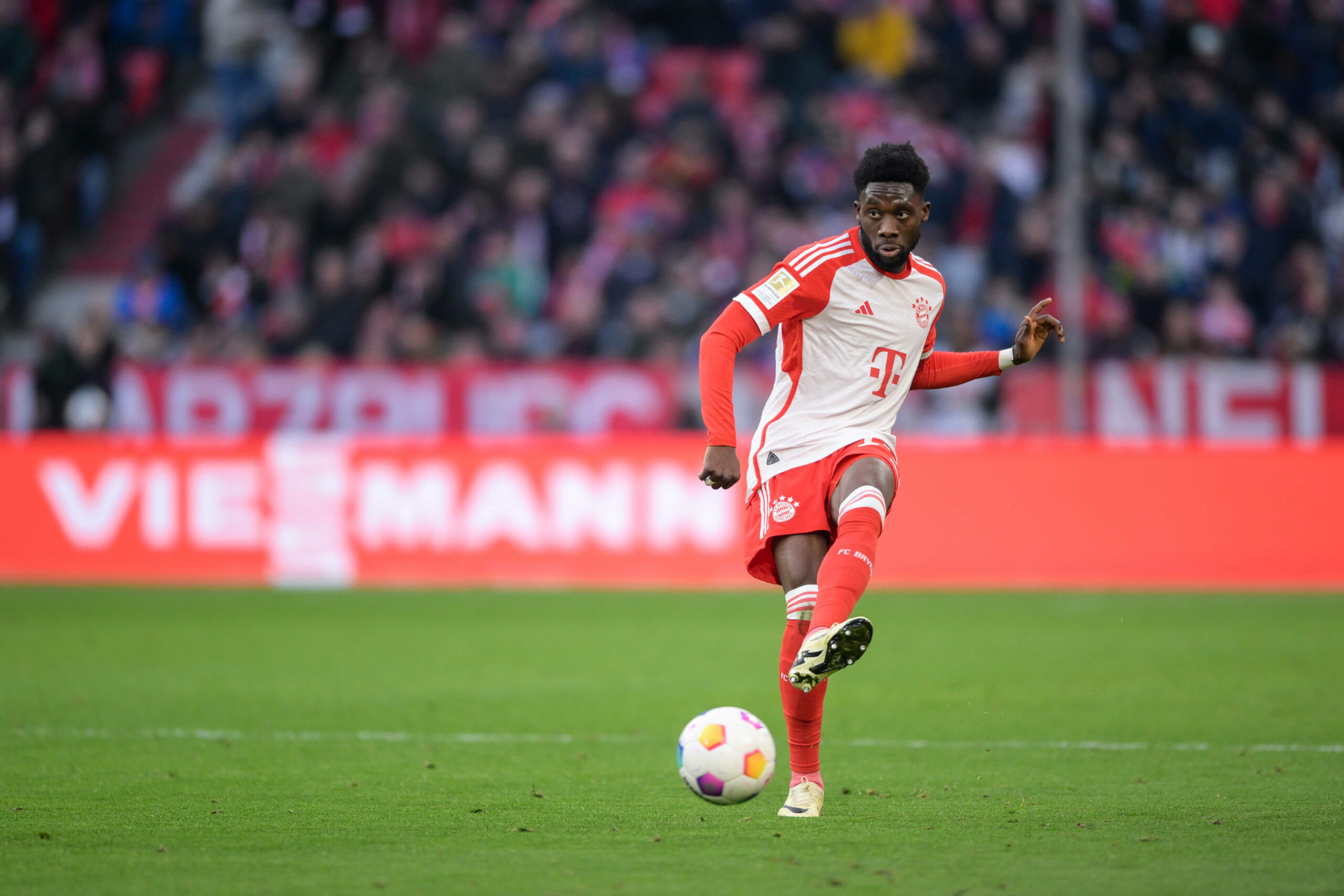 Alphonso Davies schießt den ball im Spiel.