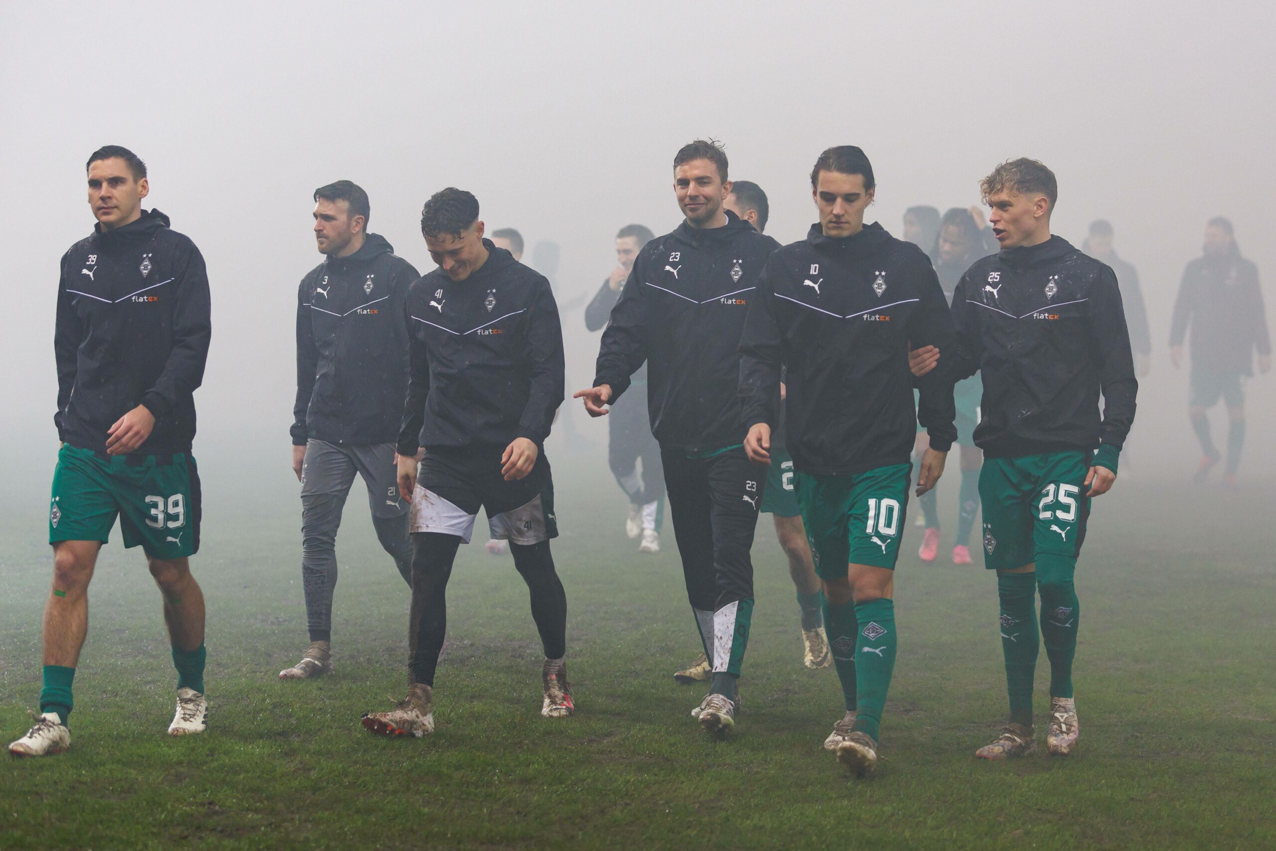 Spieler von Borussia Mönchengladbach verlassen den nassen Rasen in Saarbrücken.