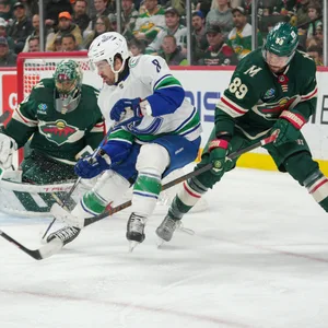 Spieler der Minnesota Wild und Vancouver Canucks kämpfen um den Puck.