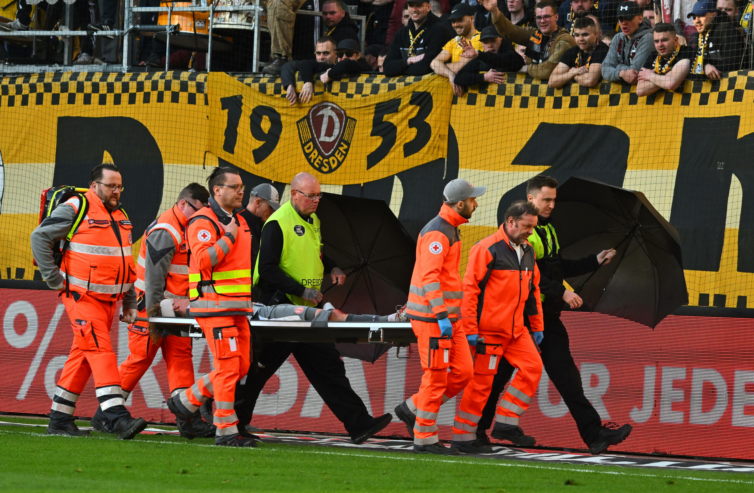 Felix Götze wird auf einer Trage von Rettungssanitätern abtransportiert.