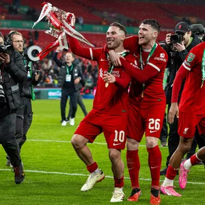 Alexis Mac Allister und Andy Robertson bejubeln den Triumph im League Cup mit dem Pokal in der Hand