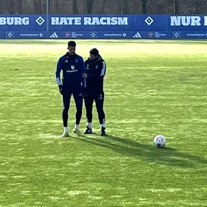 Glatzel wird von dem Reha-Trainer am Rücken berührt.