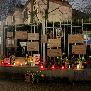 Trauer um Nawalny vor ehemaligem russischen Konsulat, am Zaun hängen Fotografien von Navalny, Briefe, es sind Blumen und Kerzen abgelegt