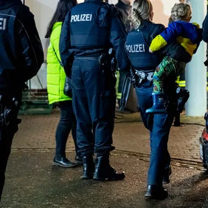 Eine Polzistin trägt den gesuchten Zweijährigen auf dem Arm.