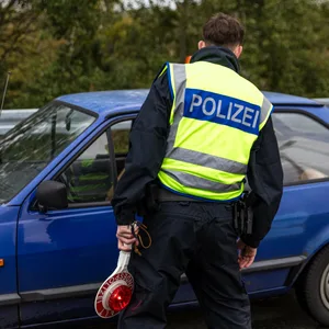 Ein Polizeibeamter spricht mit einem Autofahrer (Symbolbild).